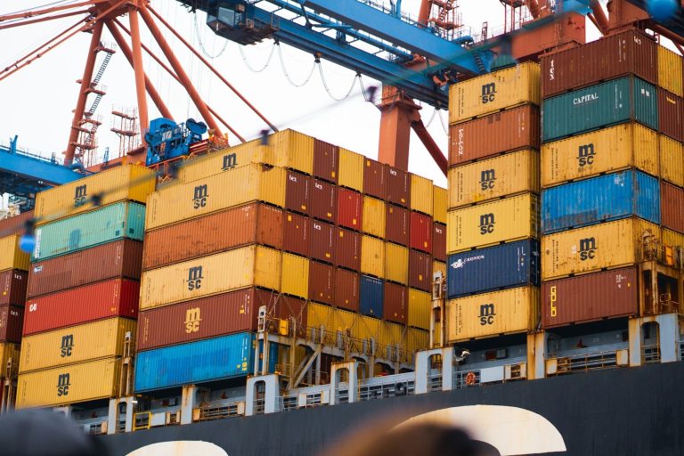 Bunte Container gestapelt auf einem Frachtschiff im Hafen.